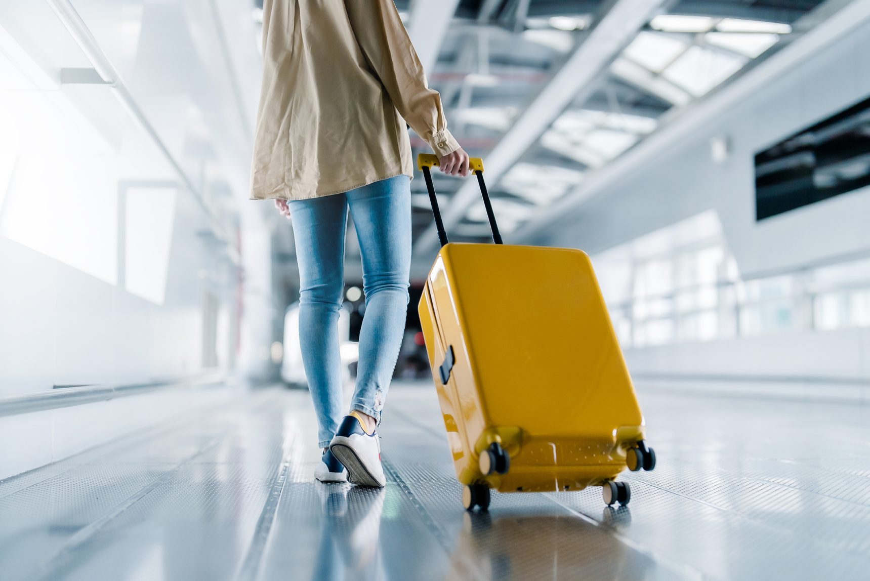 International airport terminal. Woman with luggage and walking in airport