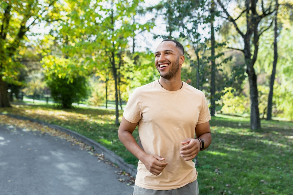 Cheerful man jogging on trail.