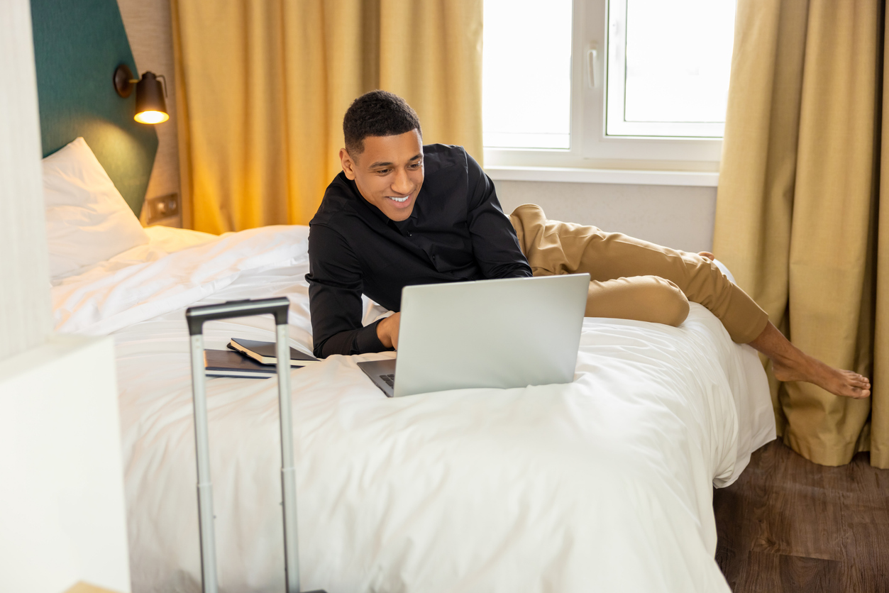 Man working remotely from a hotel room while traveling